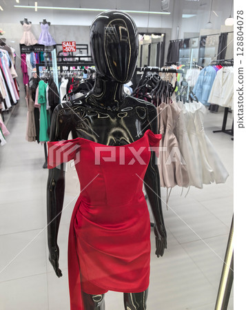 Stunning red dress on display in a boutique during afternoon shopping hours 128804078
