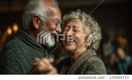 Elderly couple joyfully dancing together in their cozy living room Elderly couple joyfully dancing together in their cozy living room 128804233