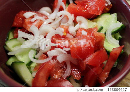 Cutted Fresh Cucumbers, Tomatoes And White Onion Sprinkled With Coarse Salt In A Salad Plate Closeup View 128804637