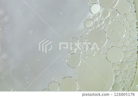 Top view of close up of oil swirling on water. Oil and water mixture concept Top view of close up of oil swirling on water. Oil and water mixture concept 128805176