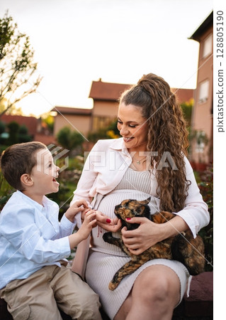Joyful moments shared between mother and son with cat Joyful moments shared between mother and son with cat 128805190