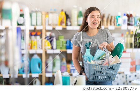 Woman with a full basket of household chemicals in the store Woman with a full basket of household chemicals in the store 128805779