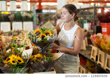 Young girl holding bouquet of sunflowers 128805836