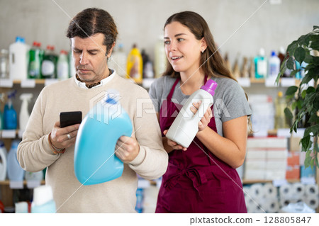 Saleswoman advising customer scanning fabric softener bottle 128805847