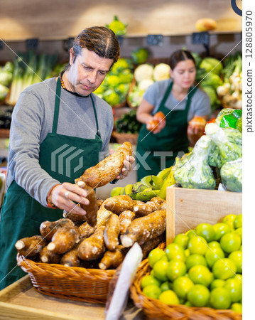 Adult man selling cassava in shop 128805970