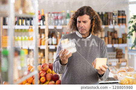 man chooses different types of cheese man chooses different types of cheese 128805980