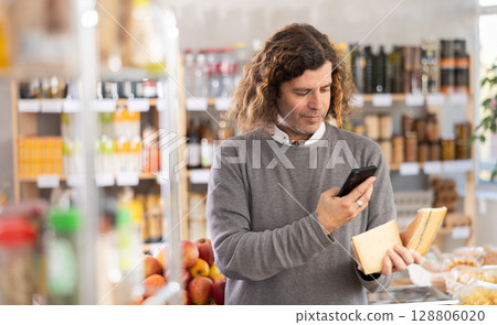 Adult man scanning qr code for cheese 128806020