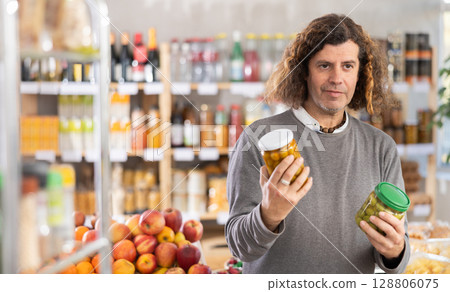 Adult man choosing olives in grocery store 128806075