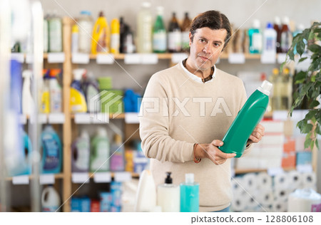 Man choosing cleaning product in supermarket Man choosing cleaning product in supermarket 128806108