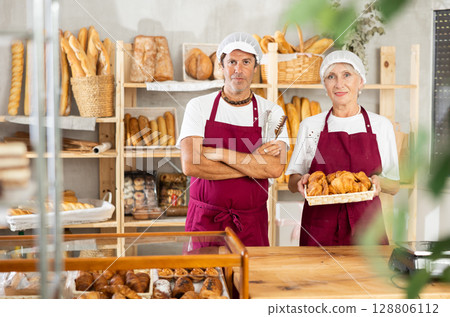 Male and female salesmen posing in bakery with croissants 128806112