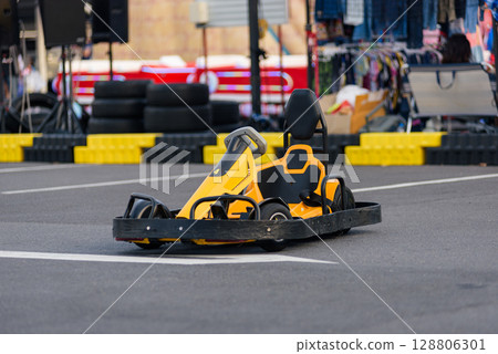 Bright yellow Go-kart speed adventure. The go kart machines are set on the asphalt track, waiting for the race to begin. 128806301