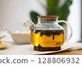 Transparent teapot with herbal tea brewing on table 128806932