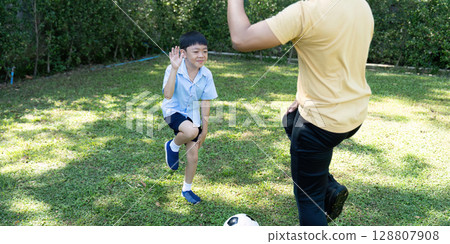 Child Practicing Soccer: Fun Interaction with Parent Child Practicing Soccer: Fun Interaction with Parent 128807908