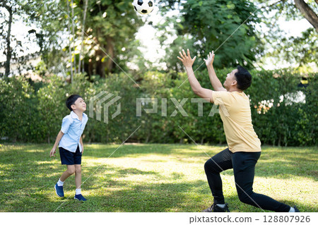 Father and Son Playing Soccer Together in Garden Father and Son Playing Soccer Together in Garden 128807926