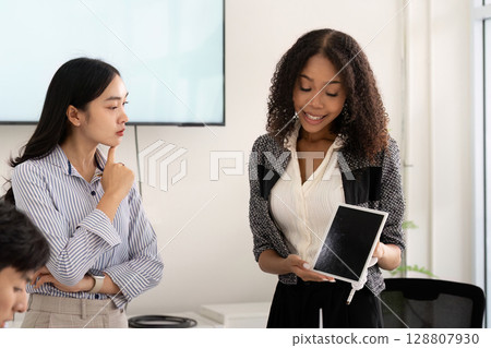 Sustainability. Female leader presenting renewable energy solutions to team. 128807930