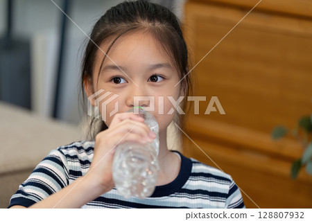 Wellness. Young girl drinking water from a bottle. 128807932