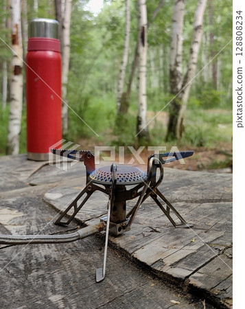 gas burner setup for cooking in serene forest during camping trip. closeup. gas burner setup for cooking in serene forest during camping trip. closeup. 128808234