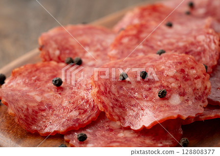 木製切菜板上的美味薩拉米香腸片 128808377