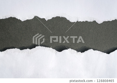 Torn white paper into half on top of black background 128808465