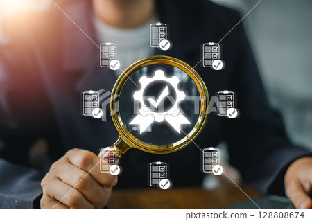 Visual representation of quality management with a magnifying glass and checkmark icons, symbolizing business excellence. 128808674