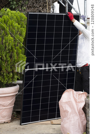 Installation of solar panels on the roof of a house 128809148