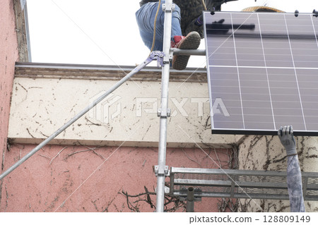 Installation of solar panels on the roof of a house Installation of solar panels on the roof of a house 128809149