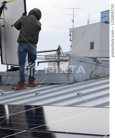 Installation of solar panels on the roof of a house 128809158