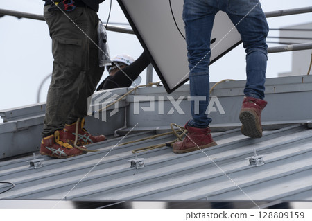 Installation of solar panels on the roof of a house Installation of solar panels on the roof of a house 128809159