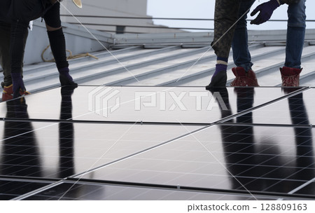 Installation of solar panels on the roof of a house 128809163