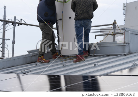 Installation of solar panels on the roof of a house 128809168
