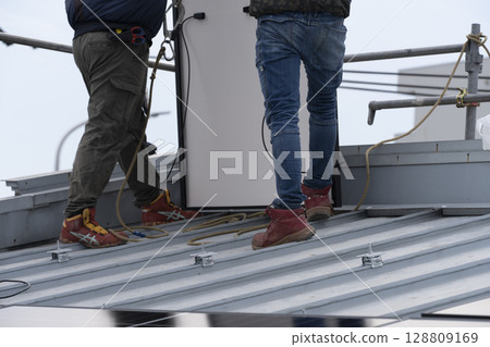 Installation of solar panels on the roof of a house 128809169