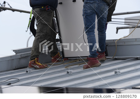 Installation of solar panels on the roof of a house 128809170
