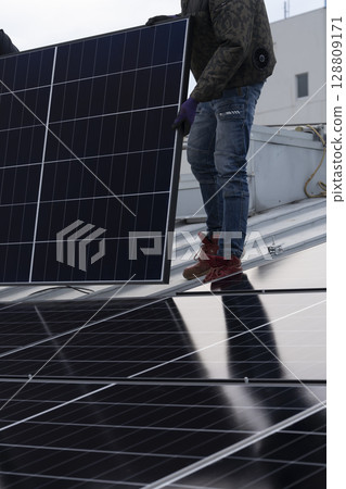 Installation of solar panels on the roof of a house 128809171