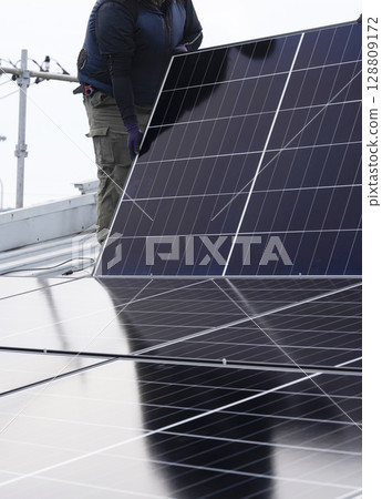 Installation of solar panels on the roof of a house 128809172