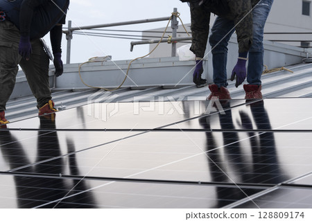Installation of solar panels on the roof of a house 128809174