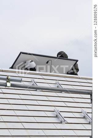 Installation of solar panels on the roof of a house 128809176