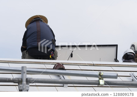 在房屋屋頂上安裝太陽能板 在房屋屋頂上安裝太陽能板 128809178