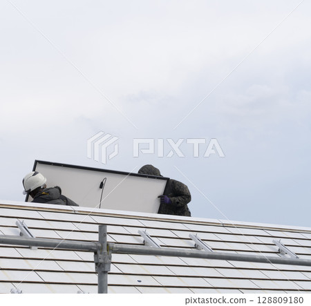 Installation of solar panels on the roof of a house 128809180