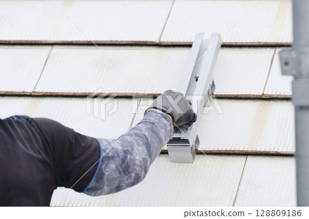 Installation of solar panels on the roof of a house 128809186