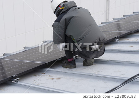 Installation of solar panels on the roof of a house 128809188