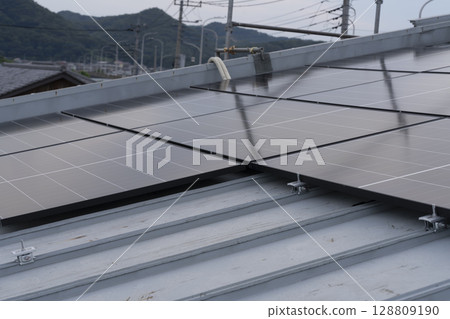 Installation of solar panels on the roof of a house 128809190