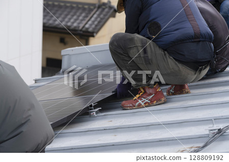 Installation of solar panels on the roof of a house 128809192
