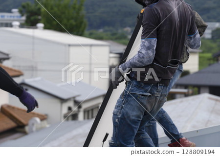 Installation of solar panels on the roof of a house 128809194