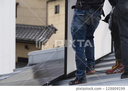 Installation of solar panels on the roof of a house 128809199