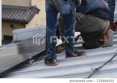 Installation of solar panels on the roof of a house Installation of solar panels on the roof of a house 128809202