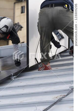 Installation of solar panels on the roof of a house 128809206