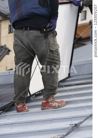 Installation of solar panels on the roof of a house Installation of solar panels on the roof of a house 128809207