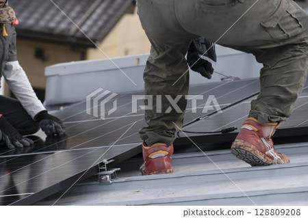 Installation of solar panels on the roof of a house 128809208