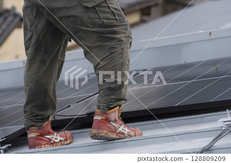 Installation of solar panels on the roof of a house 128809209