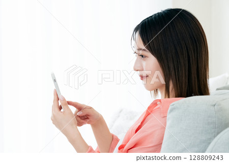 Young woman looking at a smartphone 128809243
